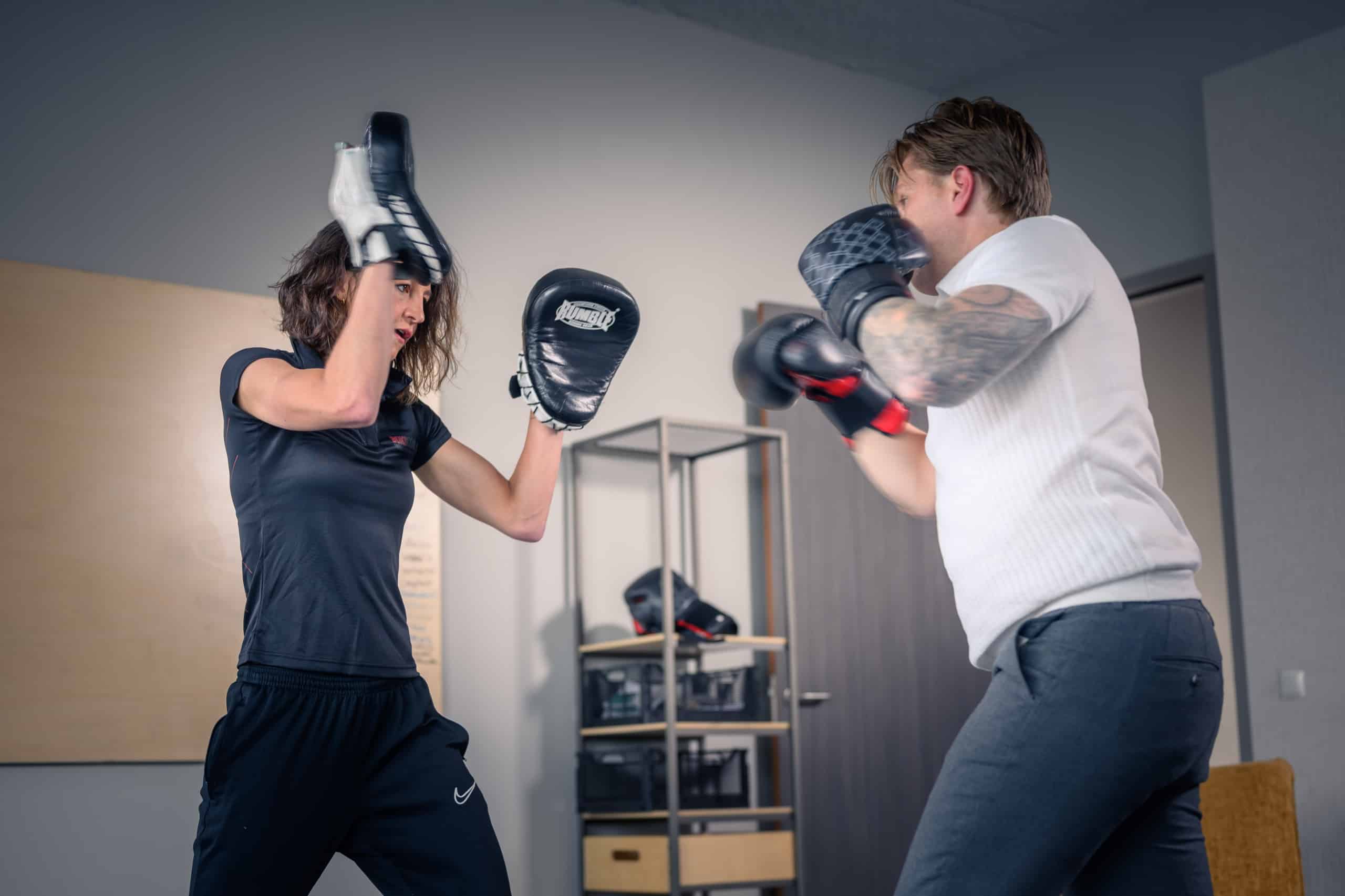 Coach vangt de stoten van een deelnemer op met handpads