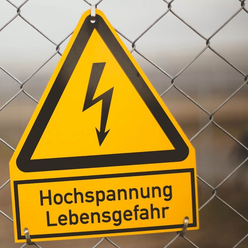 Waarschuwingsbord voor hoogspanning aan een hek