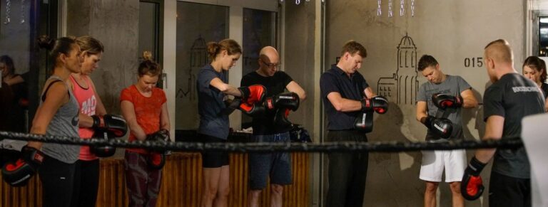 Groep deelnemers met bokshandschoenen in een boksring