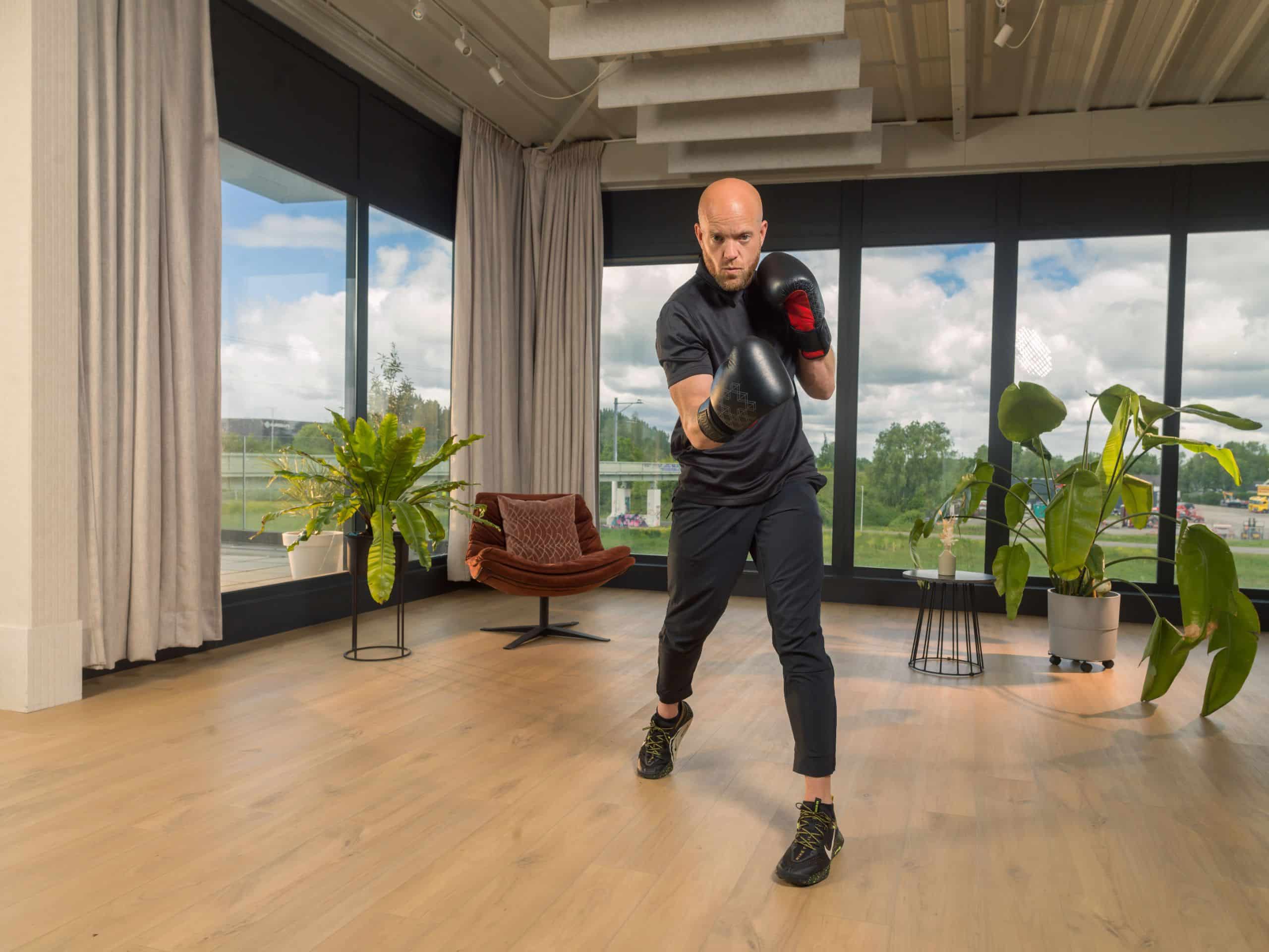 Deelnemer met bokshandschoenen in beweging in een lichte studio