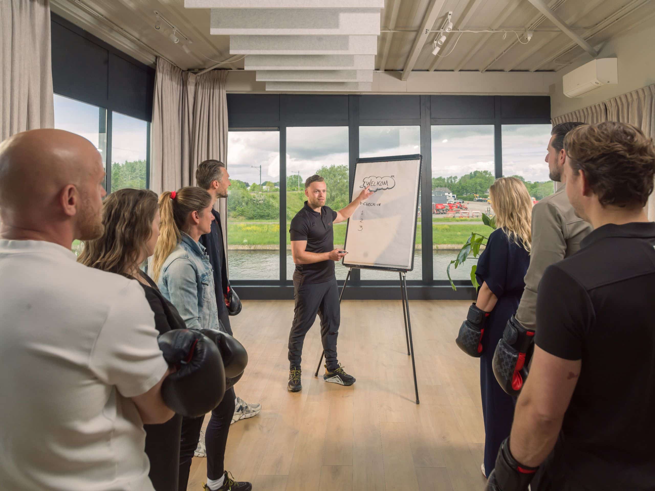 Groep deelnemers in een trainingsstudio met grote ramen