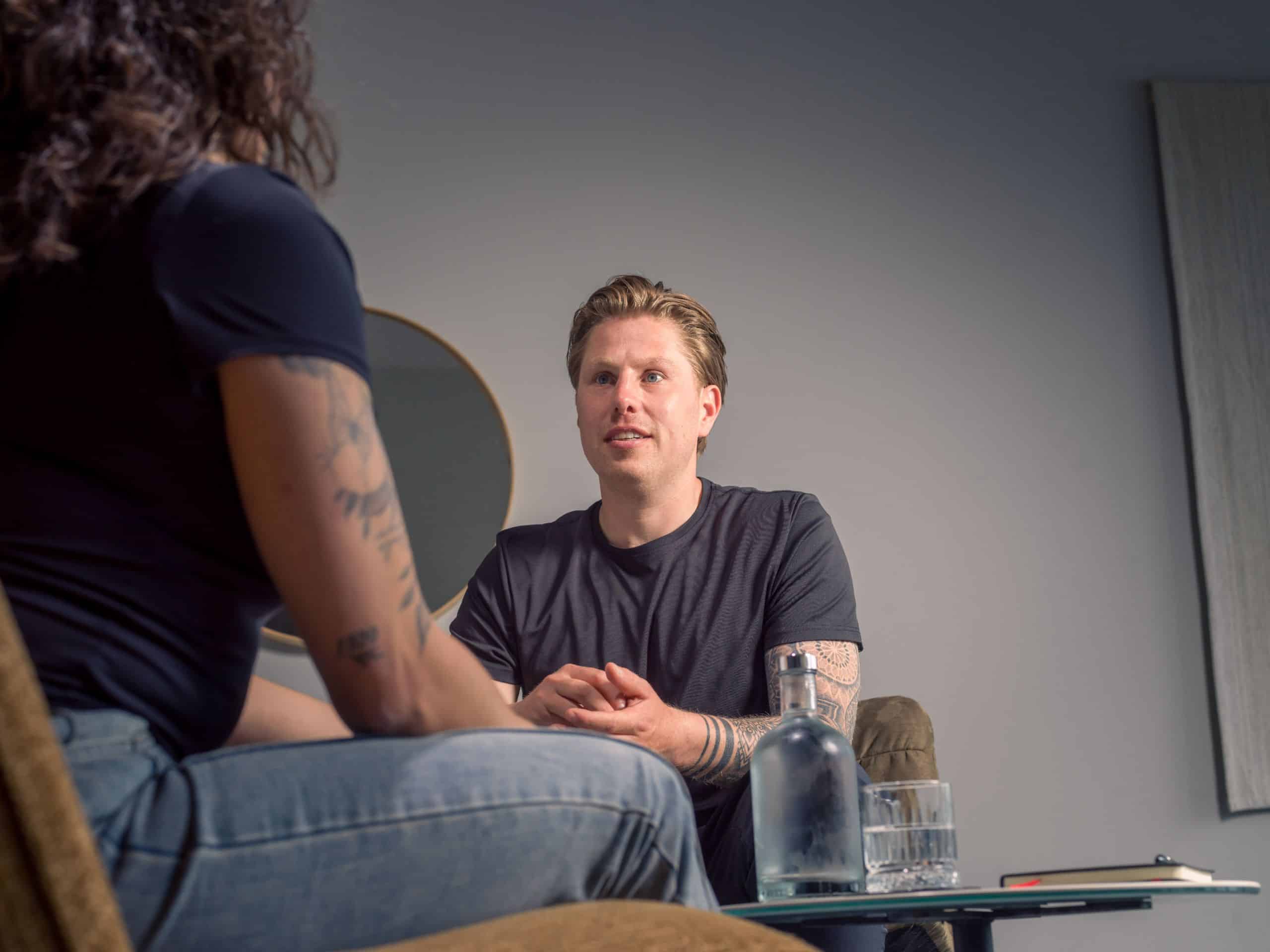 Coach in gesprek met een cliënt in een coachruimte