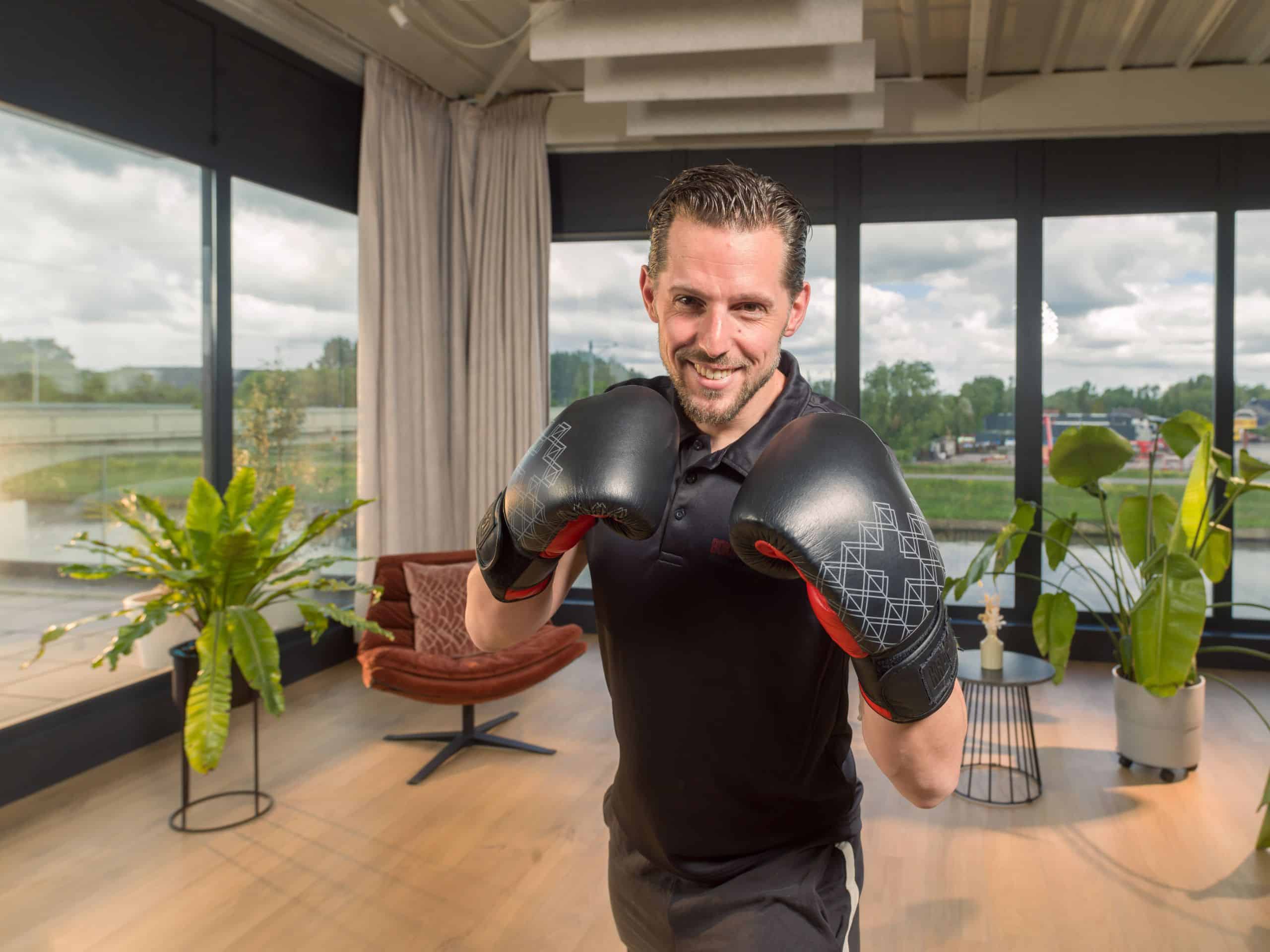 Man met bokshandschoenen in een lichte trainingsstudio